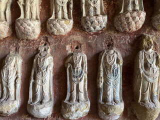 Bodhisattvas on lotus-shaped bases on walls in Dayun Ancient Grotto at Thousand-Buddha Cliff on bank of Jialing River in Guangyuan, Sichuan, China, constructed from late Northern Wei Dynasty.