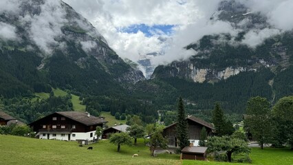 Swiss Village in Alps with Waterfall and Mountains