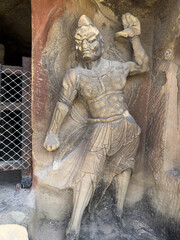 Statue of vivid guardian warrior at entrance to a grotto at Thousand-Buddha Cliff along bank of Jialing River in Guangyuan, Sichuan, China, constructed from late Northern Wei Dynasty.