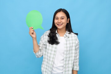 Young Asian woman showing blank paper page with saying something, smiling looking at camera, isolated blue background.
