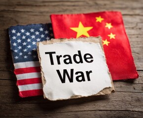 A weathered sign reading "Trade War" sits between tattered flags of the United States and China, highlighting the economic conflict.
