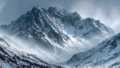Obraz premium Snowy mountain range bathed in soft light, mist and sunlight