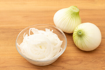 カットした新玉ねぎ　木目背景