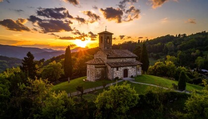 Picturesque church atop a hill bathed in golden sunlight, with rolling hills in the distance