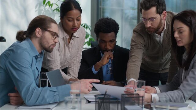Diverse business team Caucasian African American Indian businesspeople women men talking discussing in office working with documents paperwork partnership multinational coworkers briefing cooperate
