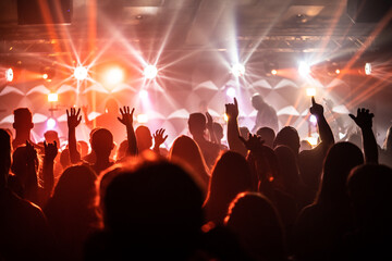 Group of People at Live Music Concert with Orange Starburst Lighting and Silhouettes