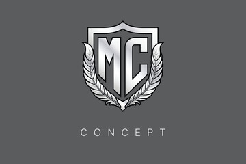 Fototapeta premium MC Creative Initial Letter Logo with Shield and Laurel Wreath Silver Metallic Branding Emblem on Gray Background.
