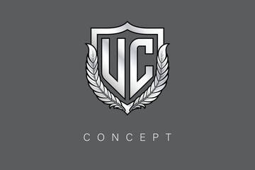 UC Creative Initial Letter Logo with Shield and Laurel Wreath Silver Metallic Branding Emblem on Gray Background.