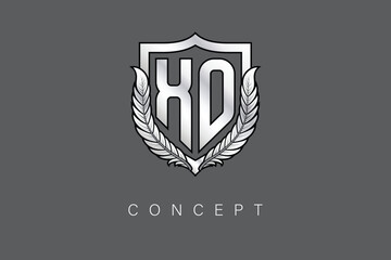 XO Creative Initial Letter Logo with Shield and Laurel Wreath Silver Metallic Branding Emblem on Gray Background.