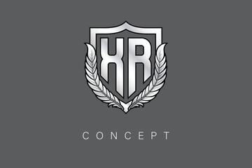 XR Creative Initial Letter Logo with Shield and Laurel Wreath Silver Metallic Branding Emblem on Gray Background.