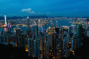 Obraz premium Landscape of skyscraper scenery aerial view on top of buildings at night in town Hong Kong. City with bright lights at night, it's beautiful with hotels and office towers in at dark is background.