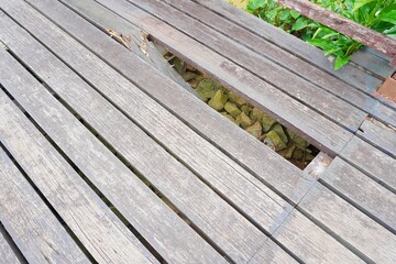 A broken piece of wood for a bridge or path due to cracking and being old and worn out.
