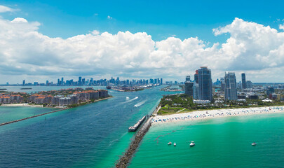 Fototapeta premium Aerial view of Miami Beach with turquoise waters. Drone shot of Miami skyline. Top view of South Beach. Miami cityscape with luxury skyscrapers and ocean. View of Miami famous coastline.