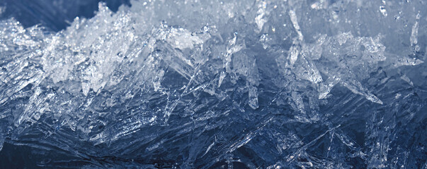 Arctic ice. Monochrome frozen background with light and shadow. A scattering of large long ice crystals in the form of needles on the river in winter.