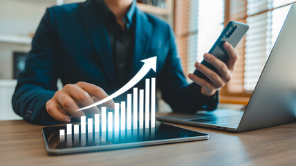 Business person analyzing growth chart on tablet with phone and laptop