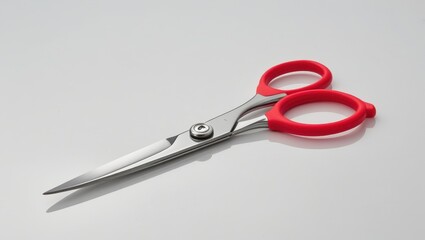 Fototapeta premium Professional, high-quality metal scissors with ergonomic, bright red handles are featured on a light gray background.