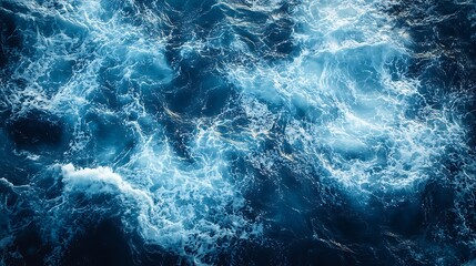 Abstract aerial scene of ocean foam forming organic patterns across deep blue water surface, wide left side negative space, calm minimal concept for sea, nature, marine and environmental visuals