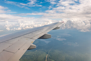 Obraz premium View from the airplane window at a beautiful cloudy sky and the airplane wing