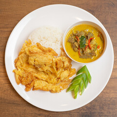 Green curry beef with omelet, a great Thai dish. It consists of steamed rice, green curry beef, which is a rich coconut milk curry, beef, and omelet, which is an egg fried until fluffy.