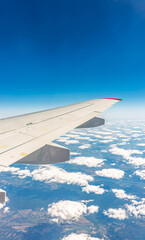 Obraz premium View from the airplane window at a beautiful cloudy sky and the airplane wing