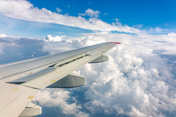 View from the airplane window at a beautiful cloudy sky and the airplane wing