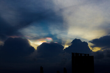 Cloud iridescence or irisation over the dark sky. occurs when sunlight reflects off water droplets in the atmosphere.