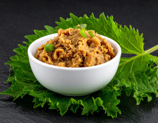 a bowl of miso paste isolated on a black background