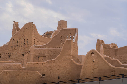 Courtyard in Diriyah, Riyadh, with mudbrick walls and open blue sky highlighting traditional Najdi desert design.
