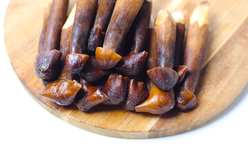 Termite mushrooms with long stems, white tips, and dark brown caps.