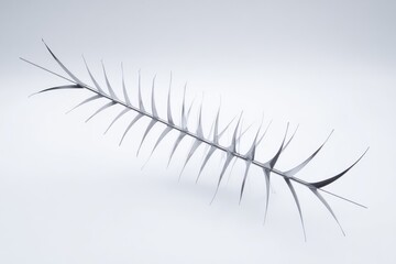 Sleek, metallic branch with sharp, pointed leaves against a light background