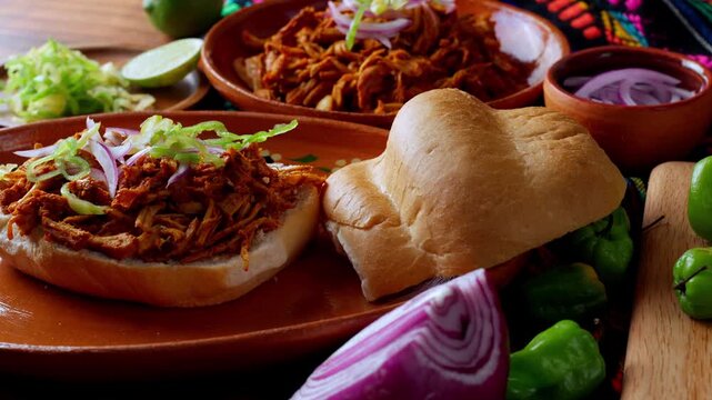Mexican food, preparing a Mexican torta sandwich cochinita pibil, serving on top habanero pepper
