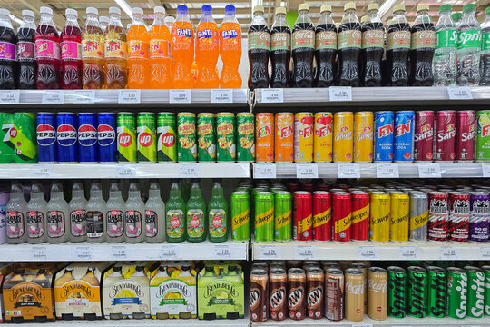 Penang, Malaysia &ndash; Aug 8, 2025: Various soft drink brands including Pepsi, 7Up, F&N, Fanta, Calpis, Hausboom, and Kickapoo displayed on supermarket shelves in bottles and cans.