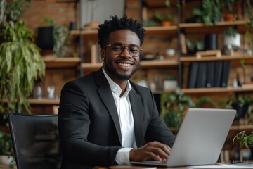 Happy young businessman sitting at a desk in the office, looking at his laptop screen with a wide smile, celebrating a recent success and showing a victory gesture with his hand, Generative AI