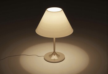 Elegant table lamp with a beige fabric shade casting a soft, warm glow on the surrounding surface in a dimly lit minimalist setting