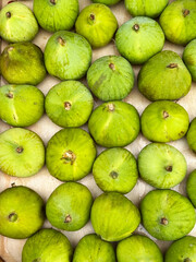 A box of fresh green figs at a local farmers market. Healthy and organic food concept.