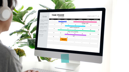 Computer with timeline project schedule, work plan mangement, on screen at office background