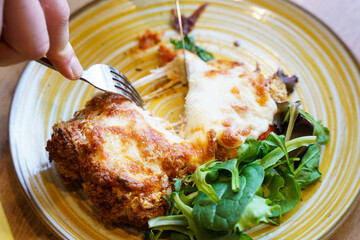 Cutting into crispy chicken parmigiana