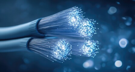Close-up of glowing fiber optic cables.  Light streams from bundled strands in a deep blue backdrop