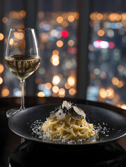 Gourmet pasta dish topped with fresh truffle shavings and a glass of white wine, set against a blurred city lights background, perfect for fine dining experiences