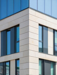 Modern office building corner with stone facade and glass

