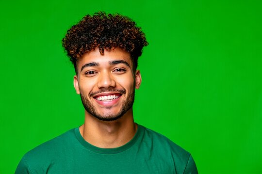 Portrait of young man smiling with curly hair on green screen background stock photo image
