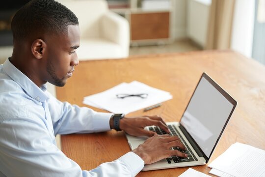 African american man working on laptop at home office remote work online business study