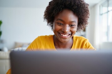 Happy african american woman working on laptop at home office remote work online learning