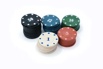 Studio photo of stacked multicolored poker chips with different denominations, arranged on a clean white background