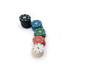Studio photo of stacked multicolored poker chips with different denominations, arranged on a clean white background