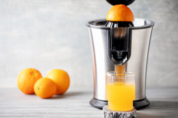 One glass of orange juice from a juicer on the table