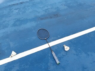 shuttlecock and badminton racket on a blue  badminton court outside the line on blue background close up. Photo taken in Malaysia © MohdHafez