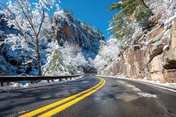 Winding snow-covered road through a rocky gorge on a sunny day