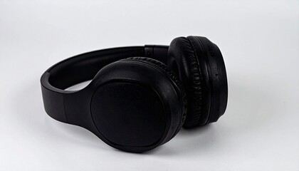 A pair of black wireless headphones resting on a plain white surface.