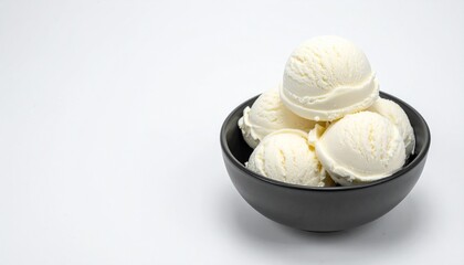 A black bowl is filled with several scoops of creamy vanilla ice cream.